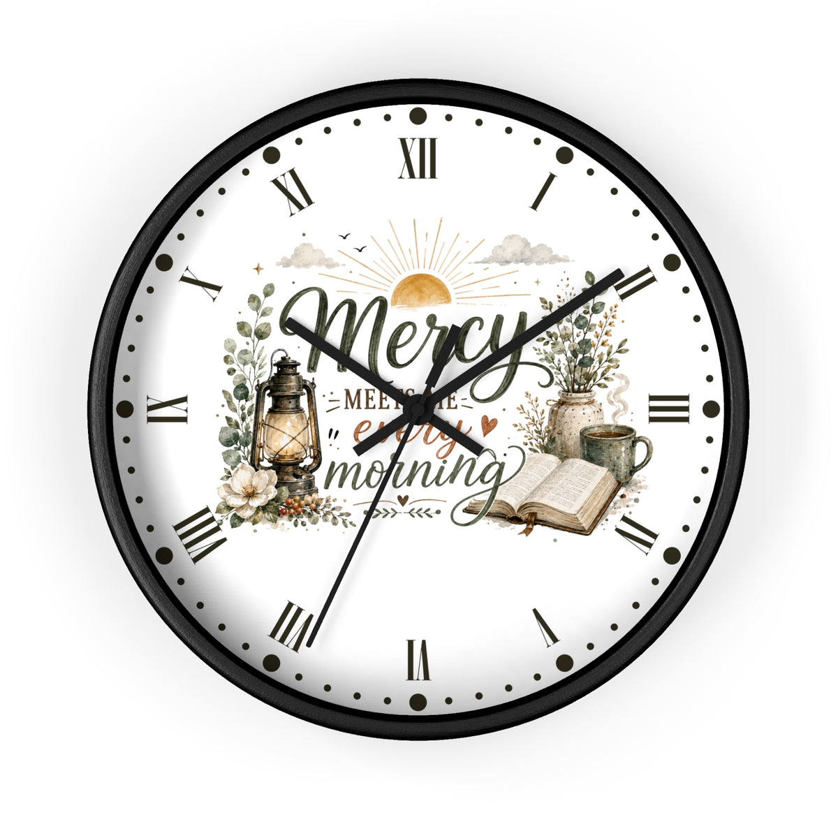 A round wall clock with a black frame and a white face featuring a vintage-style morning illustration. The design includes the words 'Mercy' and 'enjoy your morning' with a lantern, flowers, an open book, and a mug.
