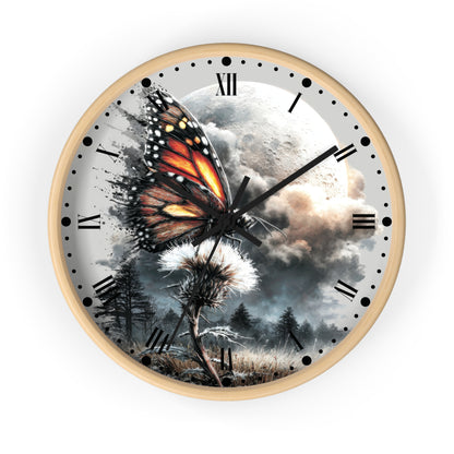 Round wall clock with a light wood frame and a surreal printed dial showing a large orange-and-black butterfly over a moonlit landscape with clouds, trees, and a dandelion, on a white background.