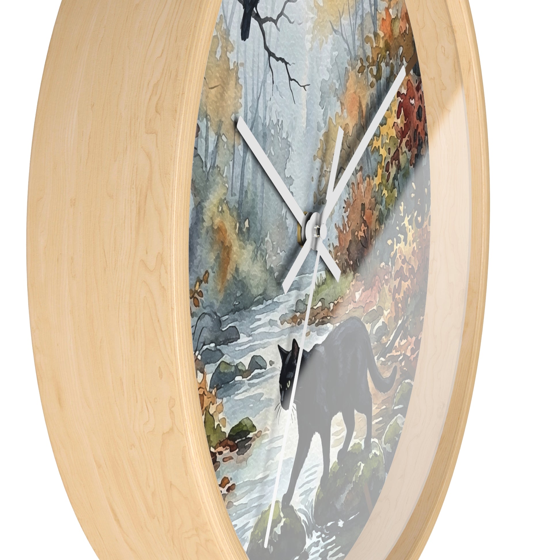 Round wall clock with a light natural wood frame and a printed scenic dial showing a forest stream, autumn foliage, and a dark cat silhouette, photographed on a white background.