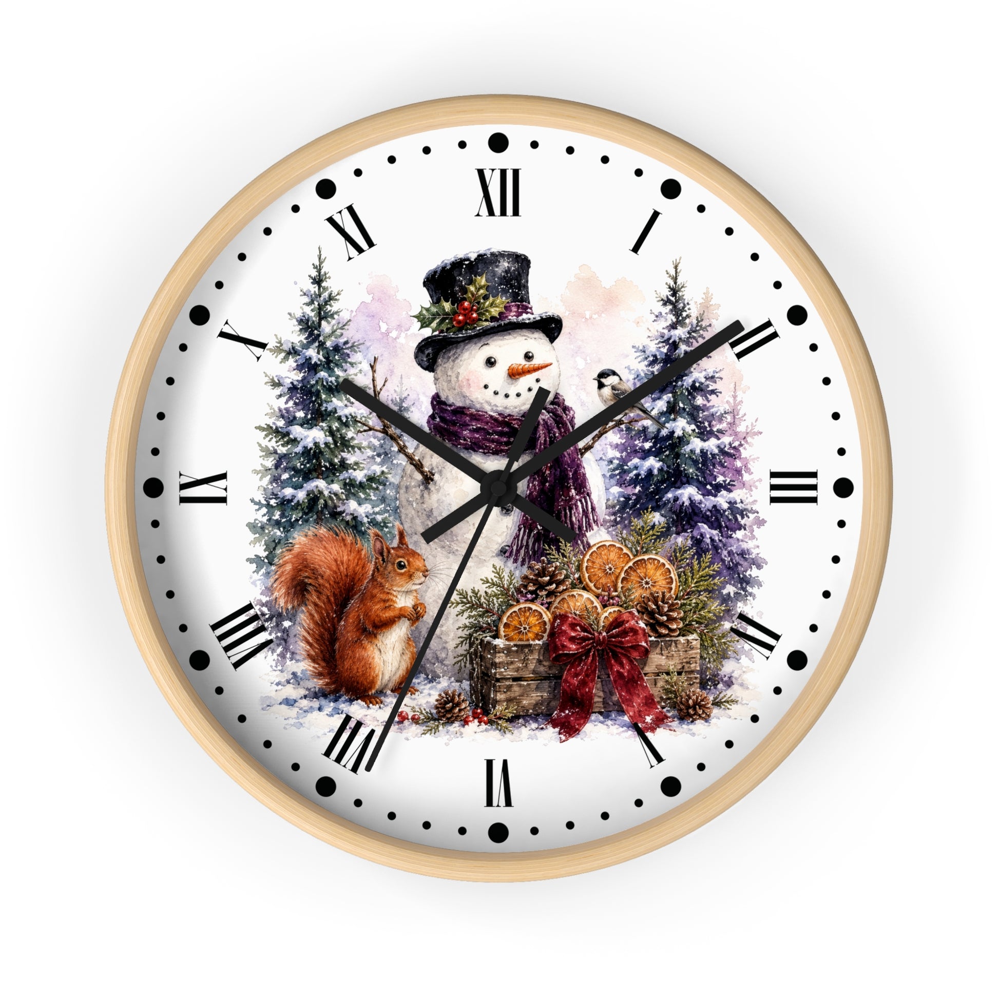 A round wall clock with a light wood frame and a white face featuring a winter holiday illustration of a snowman, a squirrel, evergreen trees, and a gift basket. The clock has black Roman numerals and hands on a clean white background.