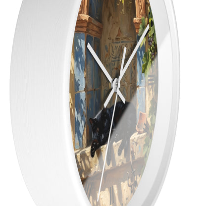 A round white wall clock with a printed scenic face showing a black cat resting on a stone ledge in front of blue tiled windows. The clock is photographed against a clean white background.