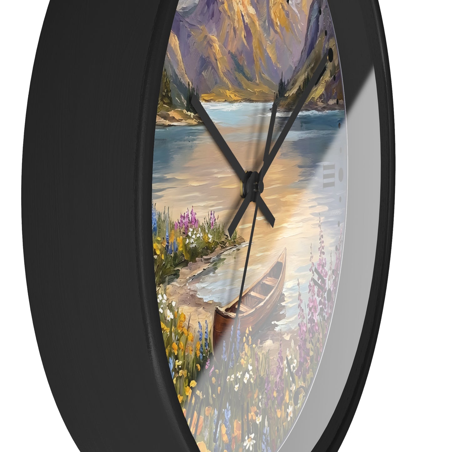 A round wall clock with a black frame and a scenic landscape print on the face, showing a lake, mountains, flowers, and a canoe. The clock is photographed against a plain white background.
