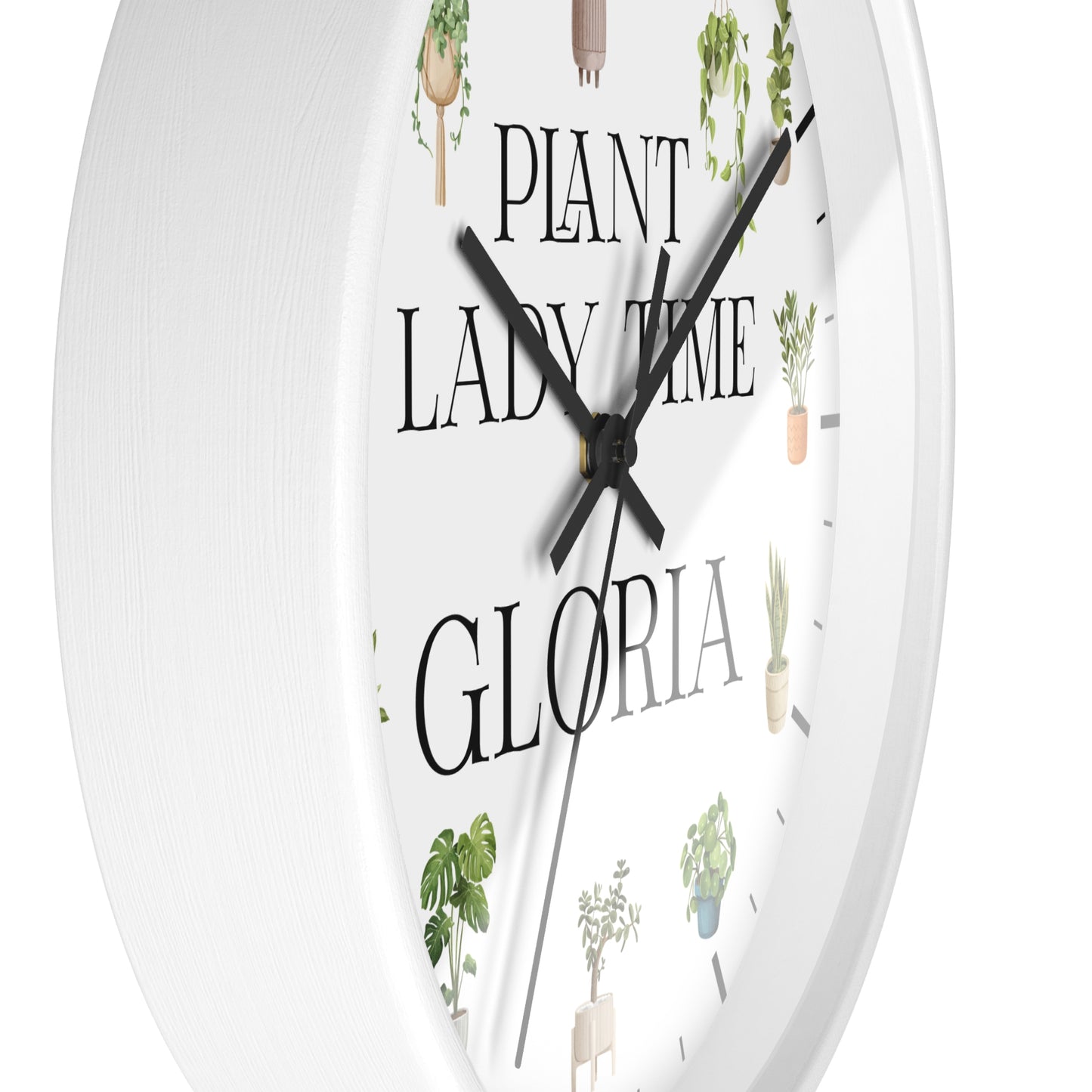 A white round wall clock with black hands and the text 'PLANT LADY TIME GLORIA' printed on the face, decorated with small illustrated potted plants.