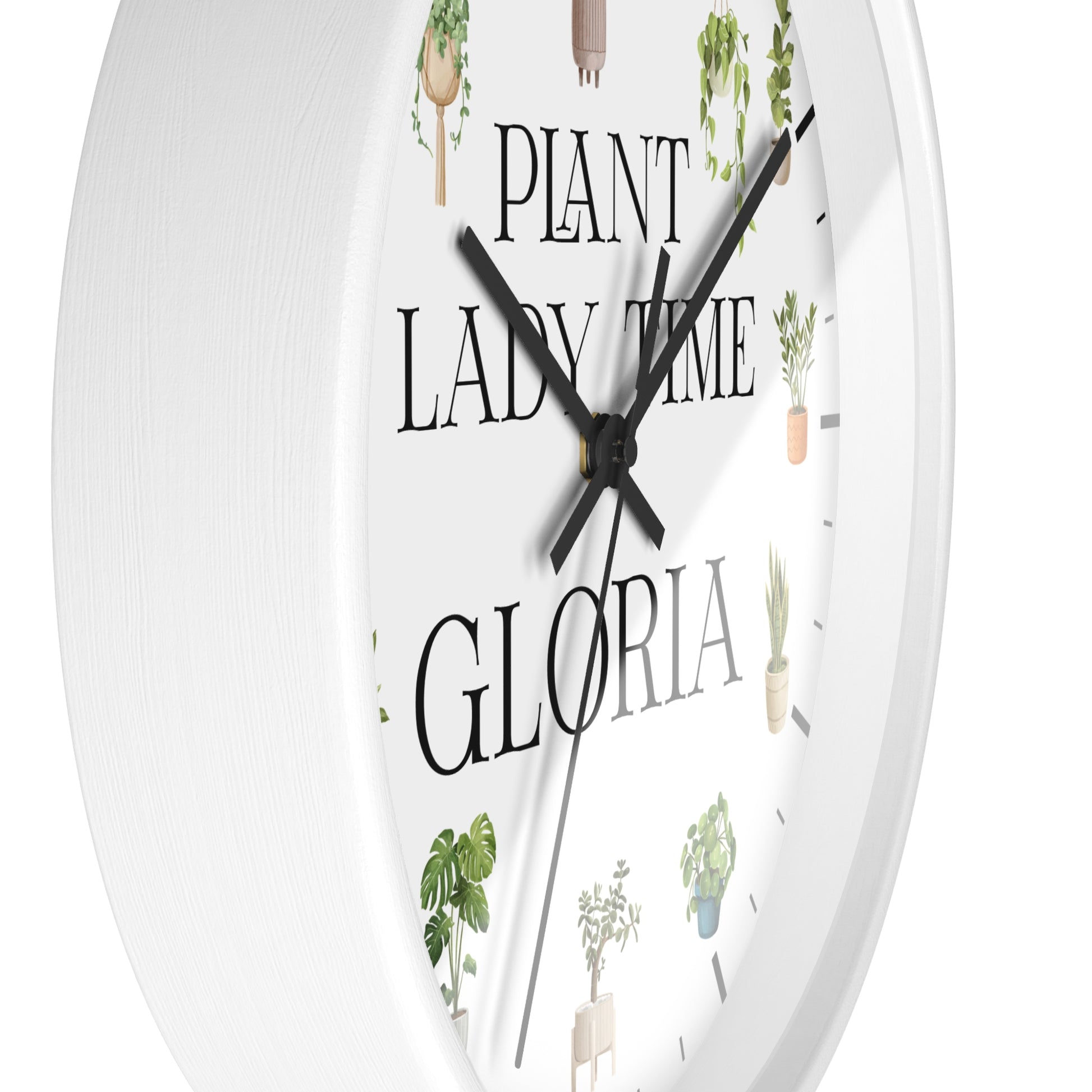 A white round wall clock with black hands and the text 'PLANT LADY TIME GLORIA' printed on the face, decorated with small illustrated potted plants.