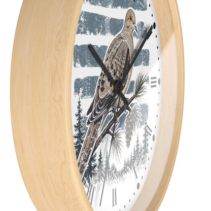 Round wall clock with a light natural wood frame and a white face featuring a detailed illustration of a brown dove  bird perched on a pine branch against a blue-and-white striped winter background.