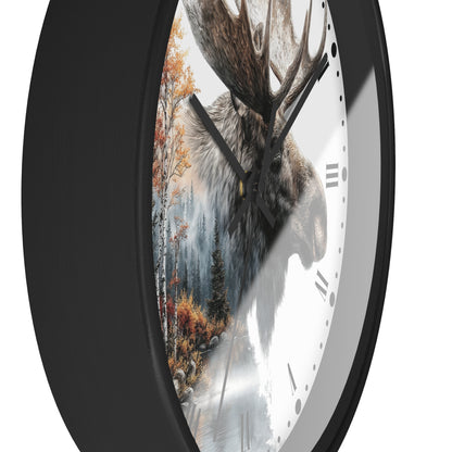 A close-up of a round wall clock with a black frame and a white face featuring a moose head over a forest scene with autumn trees.