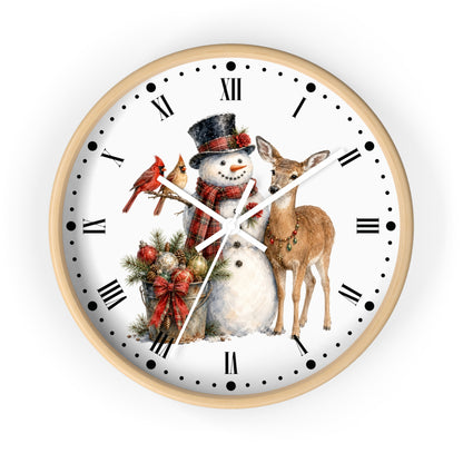 A round wall clock with a light wood frame and a white face featuring a festive Christmas illustration of a snowman, a deer, a red bird, and holiday greenery, with black Roman numerals and markers.