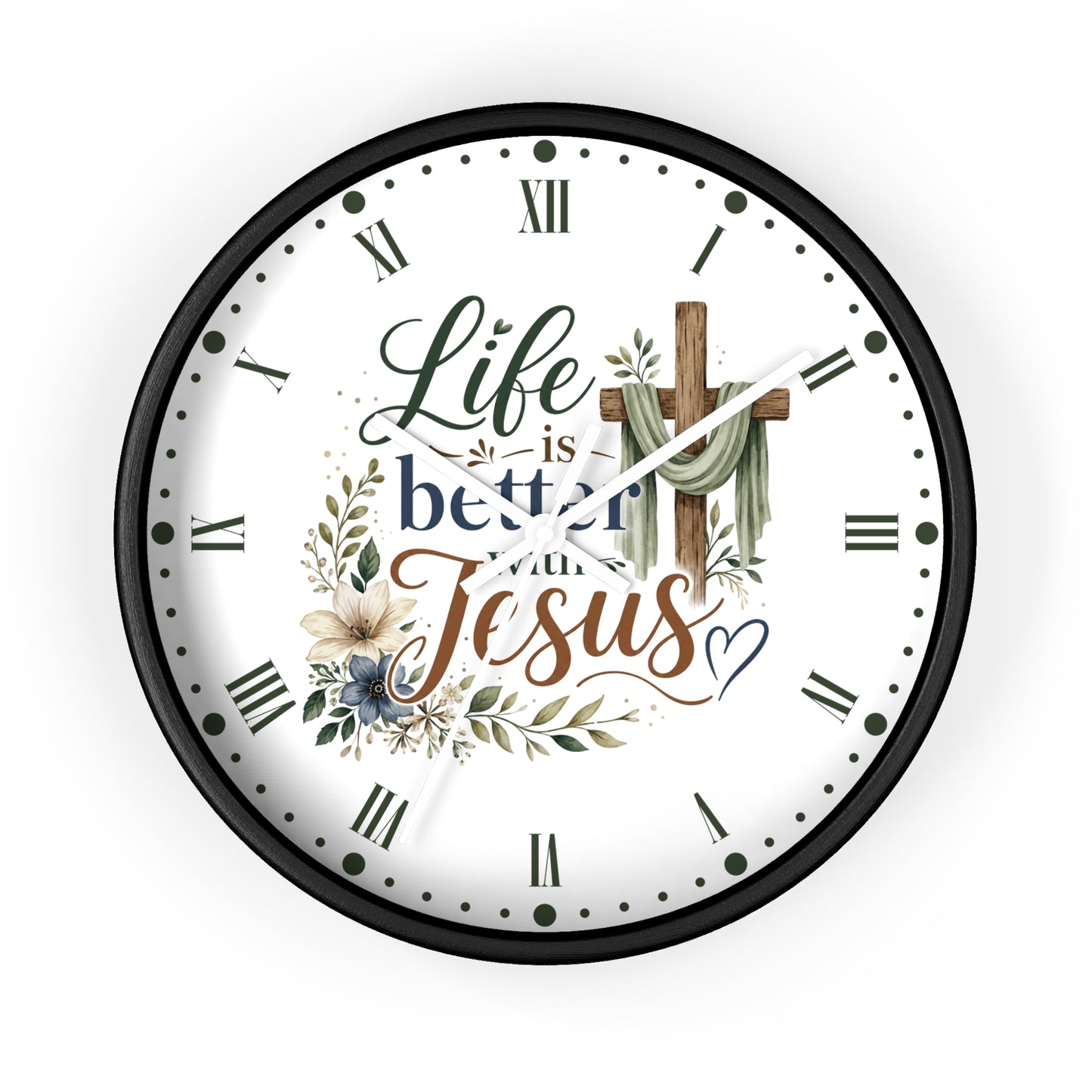 A round wall clock with a black frame and a white face featuring the text 'Life is better with Jesus' in decorative script, surrounded by floral and leaf illustrations and a wooden cross.