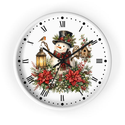A round white wall clock with a festive Christmas illustration on the face, featuring a snowman in a top hat, red poinsettias, green foliage, a bird, a lantern, and a birdhouse. The clock has black Roman numerals, black hour and minute hands, and a white outer rim, shown against a plain white background.