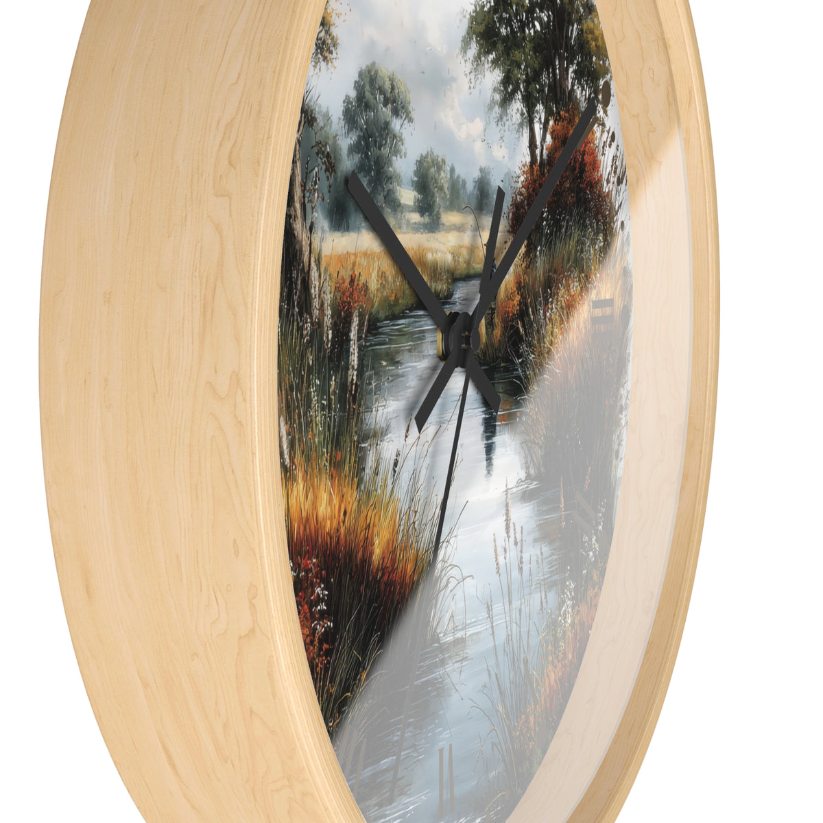 Round wall clock with a light natural wood frame and a scenic landscape print of a stream winding through tall grasses and trees, shown against a plain white background.