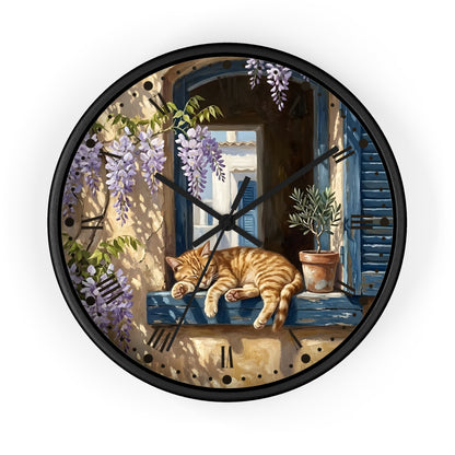 Round wall clock with a black frame and a printed illustration of a sleeping orange tabby cat on a blue windowsill, surrounded by purple wisteria flowers and a potted plant.
