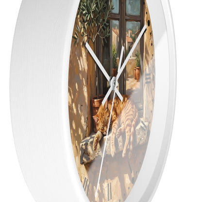 Round white wall clock with a printed scenic illustration of an orange tabby cat lying on a sunlit balcony, shown against a plain white background.