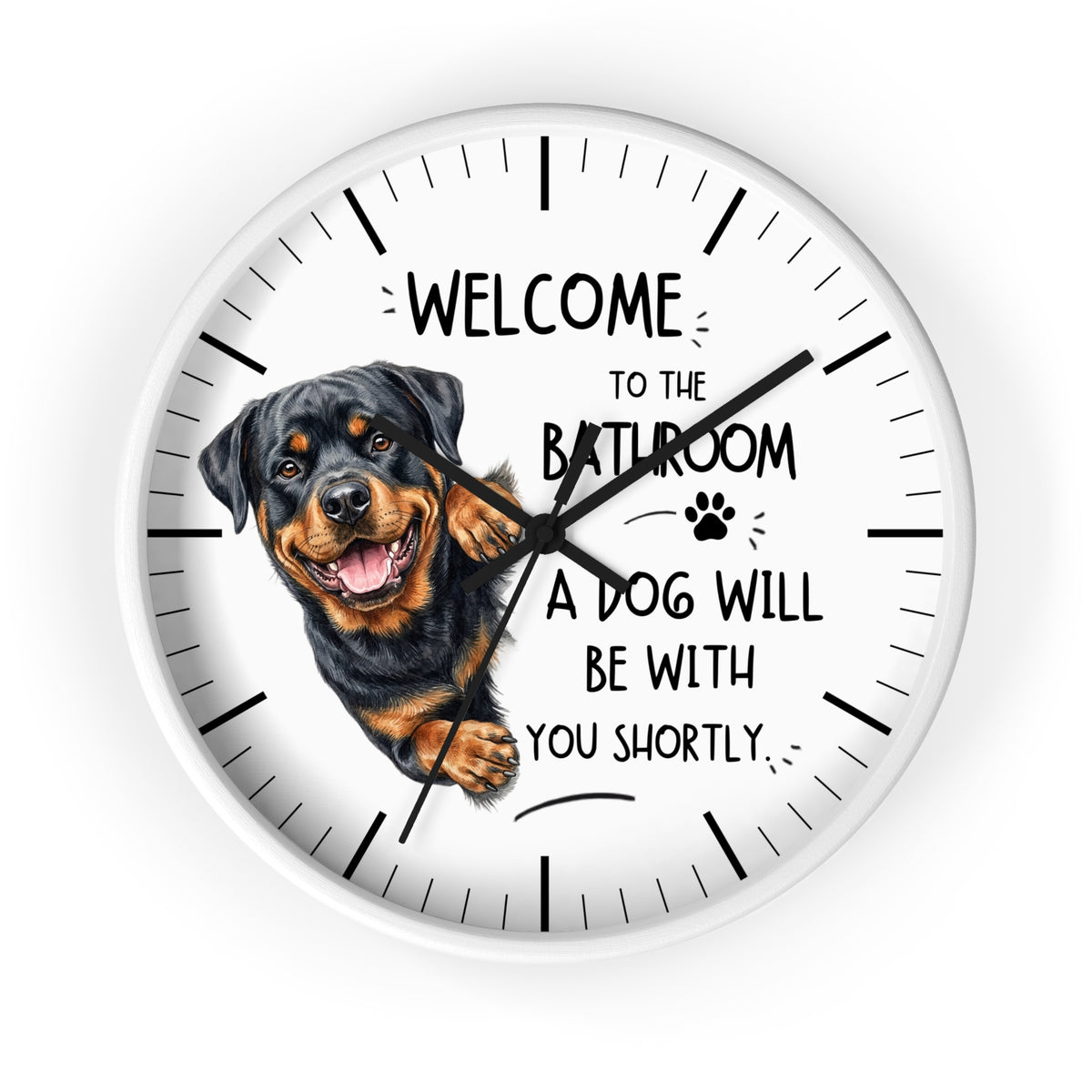 A round wall clock with a white face, black hands, black hour markers, and a printed illustration of a Rottweiler dog next to the humorous text, 'WELCOME TO THE BATHROOM A DOG WILL BE WITH YOU SHORTLY.'.