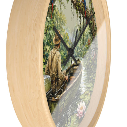 Round wall clock with a light natural wood frame and a printed scenic dial showing a man rowing a boat on a river surrounded by lush green trees. Black clock hands and white Arabic numerals are visible against a plain white background.