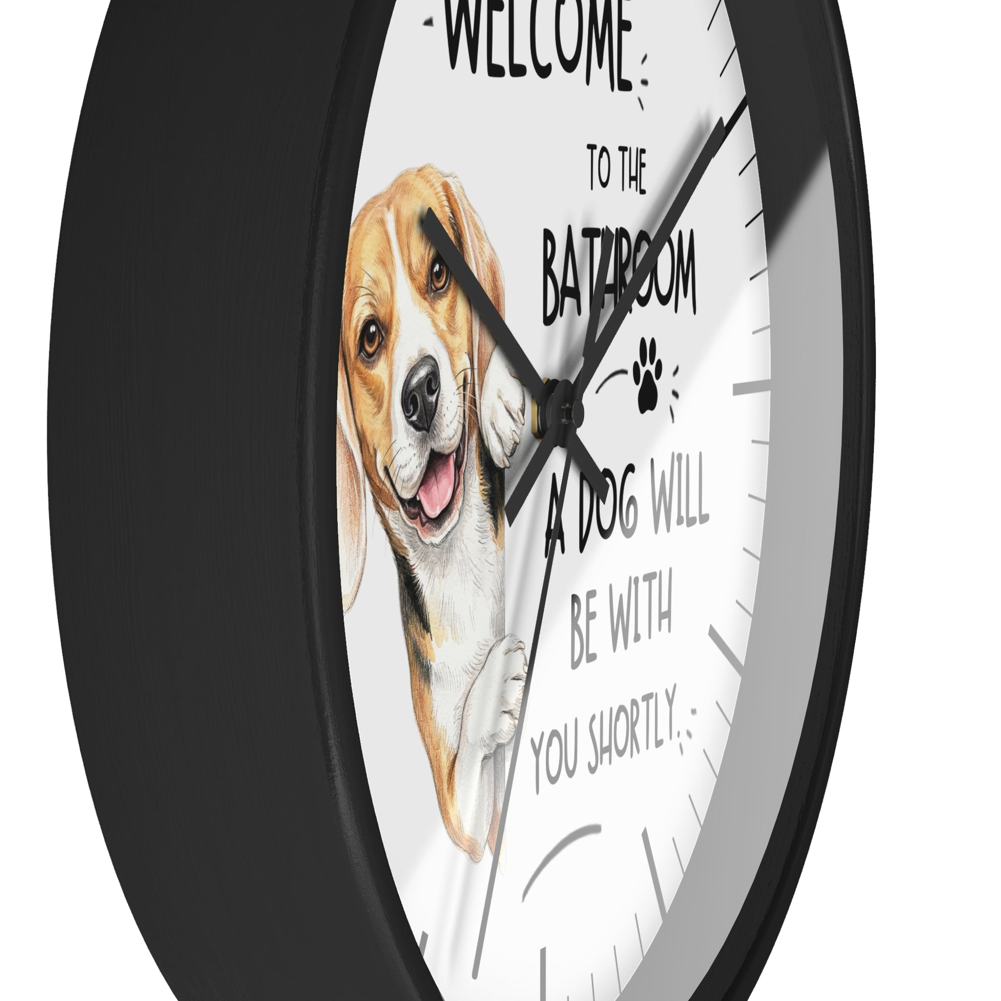 A round wall clock with a black frame and a white face featuring a painted beagle illustration and the text 'WELCOME TO THE BATHROOM A DOG WILL BE WITH YOU SHORTLY'.