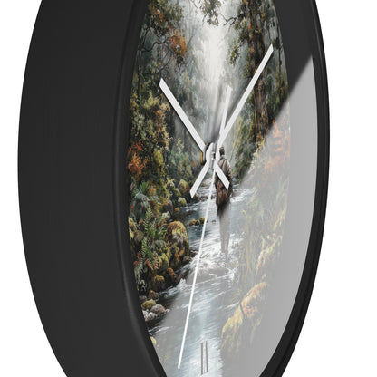 Round wall clock with a black frame and a printed nature scene on the face, showing a waterfall, forest, and flowing stream. The clock has white hands and is photographed against a plain white background.