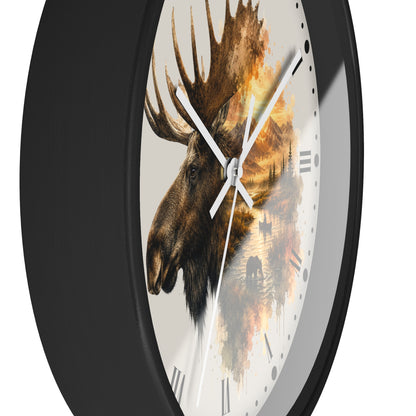 A round wall clock with a black frame and a white face featuring a moose head and a warm-toned forest scene in a watercolor-style print.