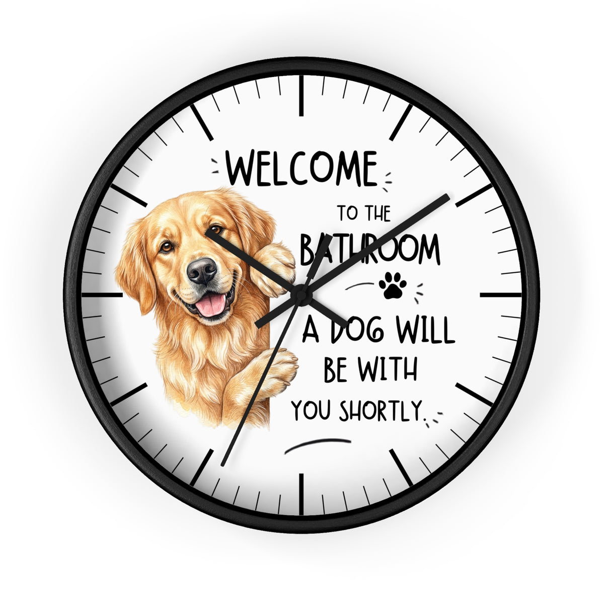 A round wall clock with a black frame and white face, featuring a golden retriever illustration and the text 'WELCOME TO THE BATHROOM A DOG WILL BE WITH YOU SHORTLY.' on a light gray background.