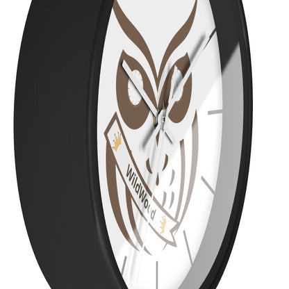 A close-up of a round wall clock with a black frame and a white face featuring a brown owl graphic and a banner that reads 'WildWorld'.