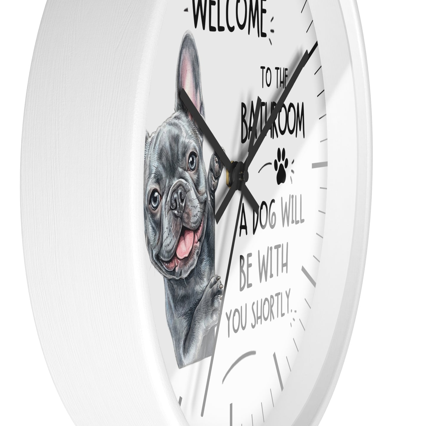 A round white wall clock with a printed illustration of a gray French bulldog and the text 'WELCOME TO THE BATHROOM A DOG WILL BE WITH YOU SHORTLY.' on a clean white background.