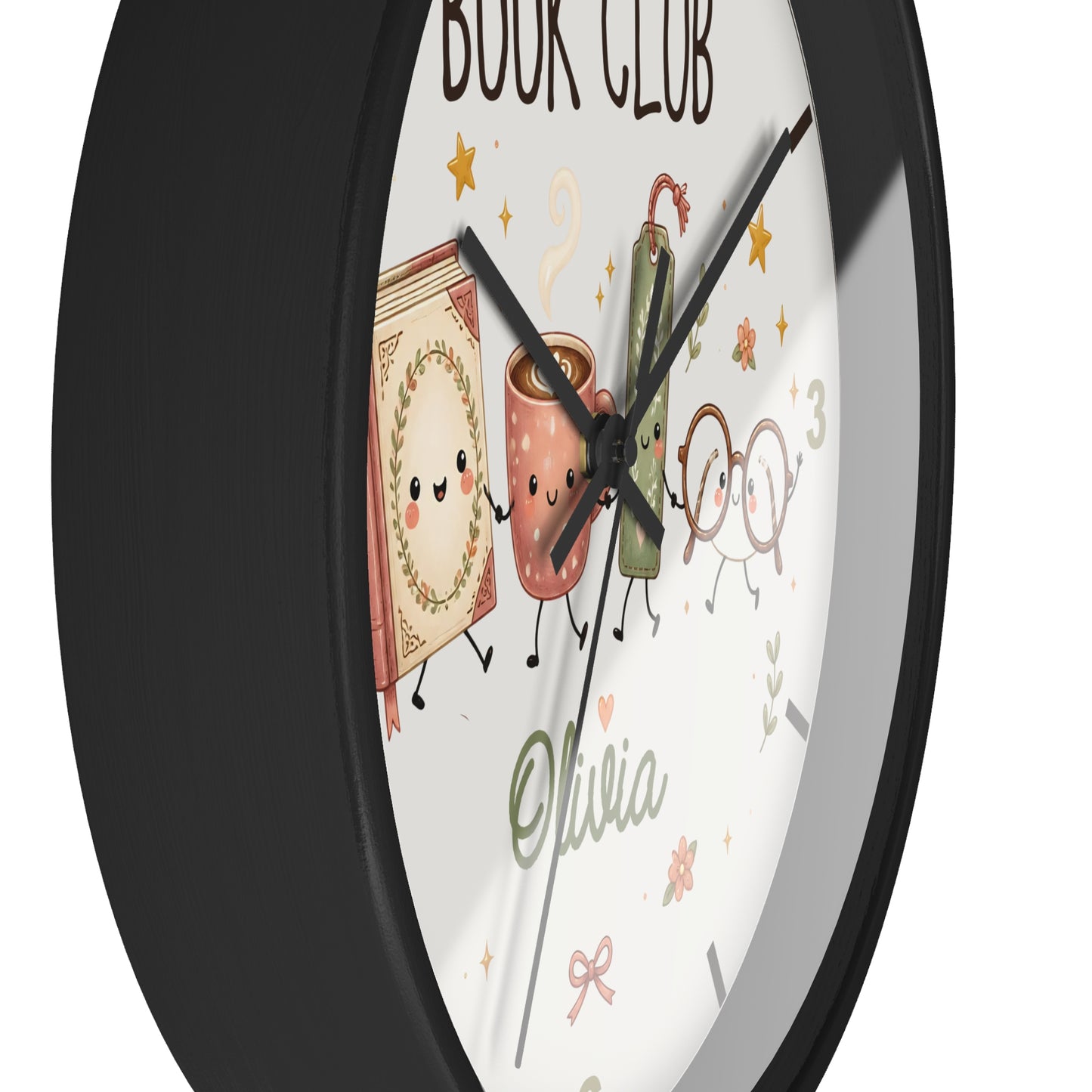 A round wall clock with a black frame and a white face featuring cute illustrated book and coffee cup characters, the words 'BOOK CLUB,' the name 'Olivia,' and decorative stars and leaves.