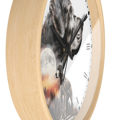A round wall clock with a light natural wood frame and a white face featuring a printed collage of gray dogs, a full moon, and a sunset landscape. The clock is shown at an angle against a plain white background.