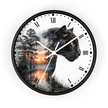 A round wall clock with a black frame and a white face featuring a split design: a black panther on one side and a misty forest sunset on the other. The clock has black Roman numerals and white hands, shown against a plain white background.