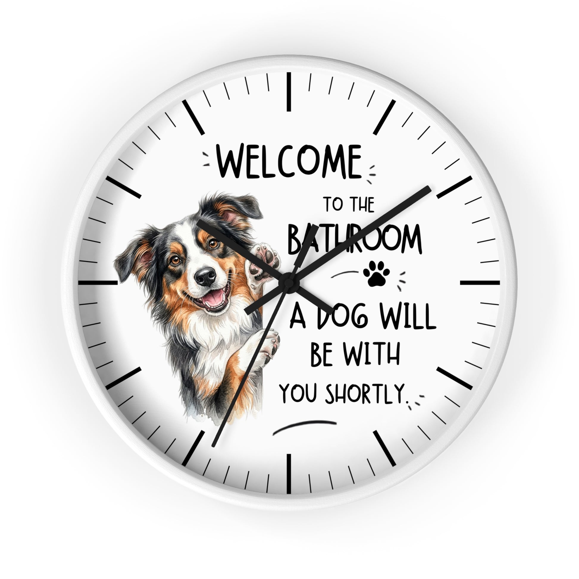 A round wall clock with a white face and black hands, featuring a Australian shepherd dog illustration and the text 'WELCOME TO THE BATHROOM A DOG WILL BE WITH YOU SHORTLY.' on a light gray background.