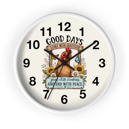 A round wall clock with a white frame and an off-white dial featuring a central illustration of a brown chicken surrounded by sunflowers and butterflies. The text on the dial reads 'GOOD DAYS START WITH GRATITUDE' and 'grow with kindness AND END WITH PEACE.