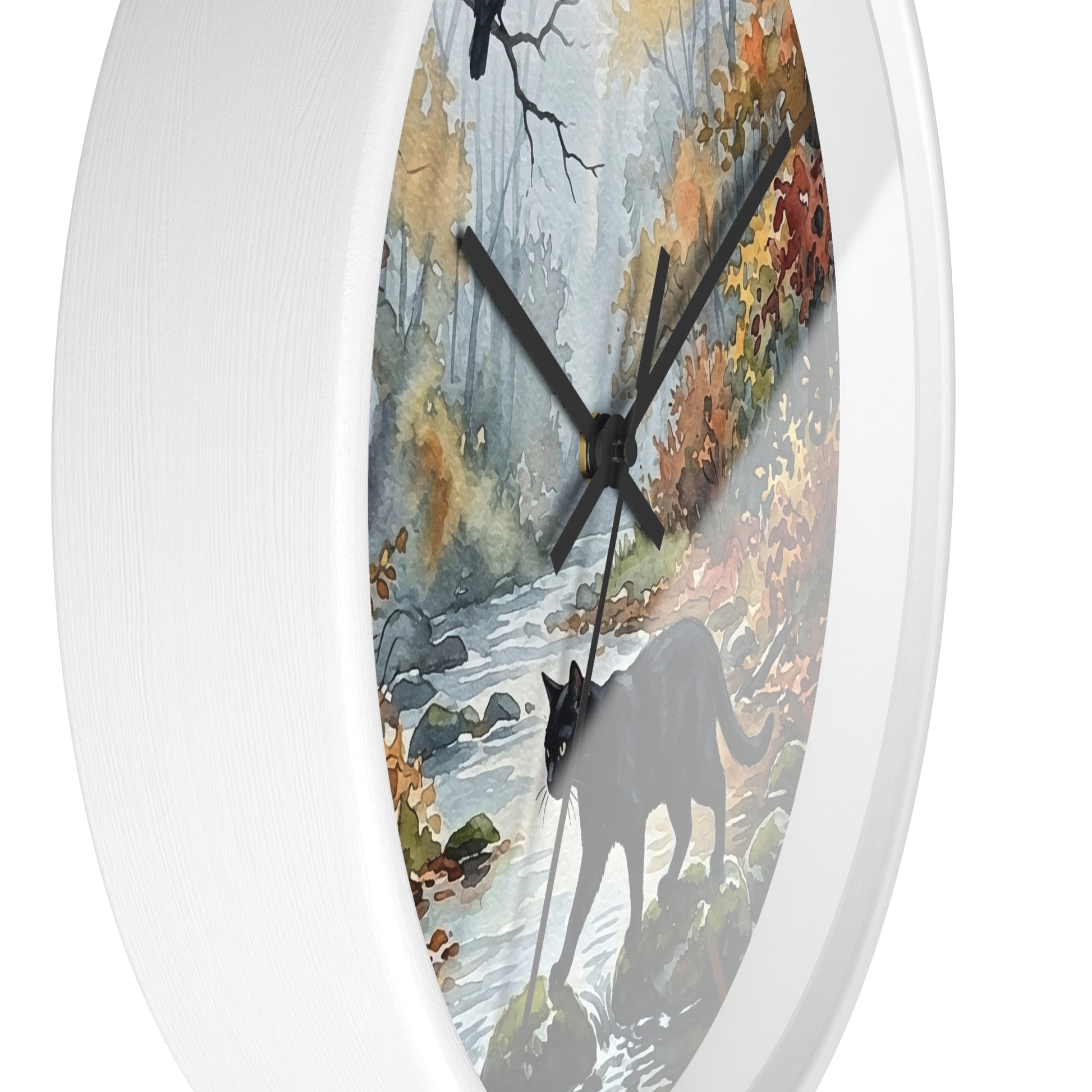 A round wall clock with a white frame and a printed nature scene on the face, showing a forest stream, autumn foliage, and a black cat silhouette. The clock is photographed against a clean white background.