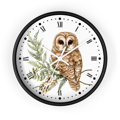 A round wall clock with a black frame and a white face, featuring a detailed illustration of a brown owl perched on a green branch with acorns. The clock uses Roman numerals for hour markers and has white hands.