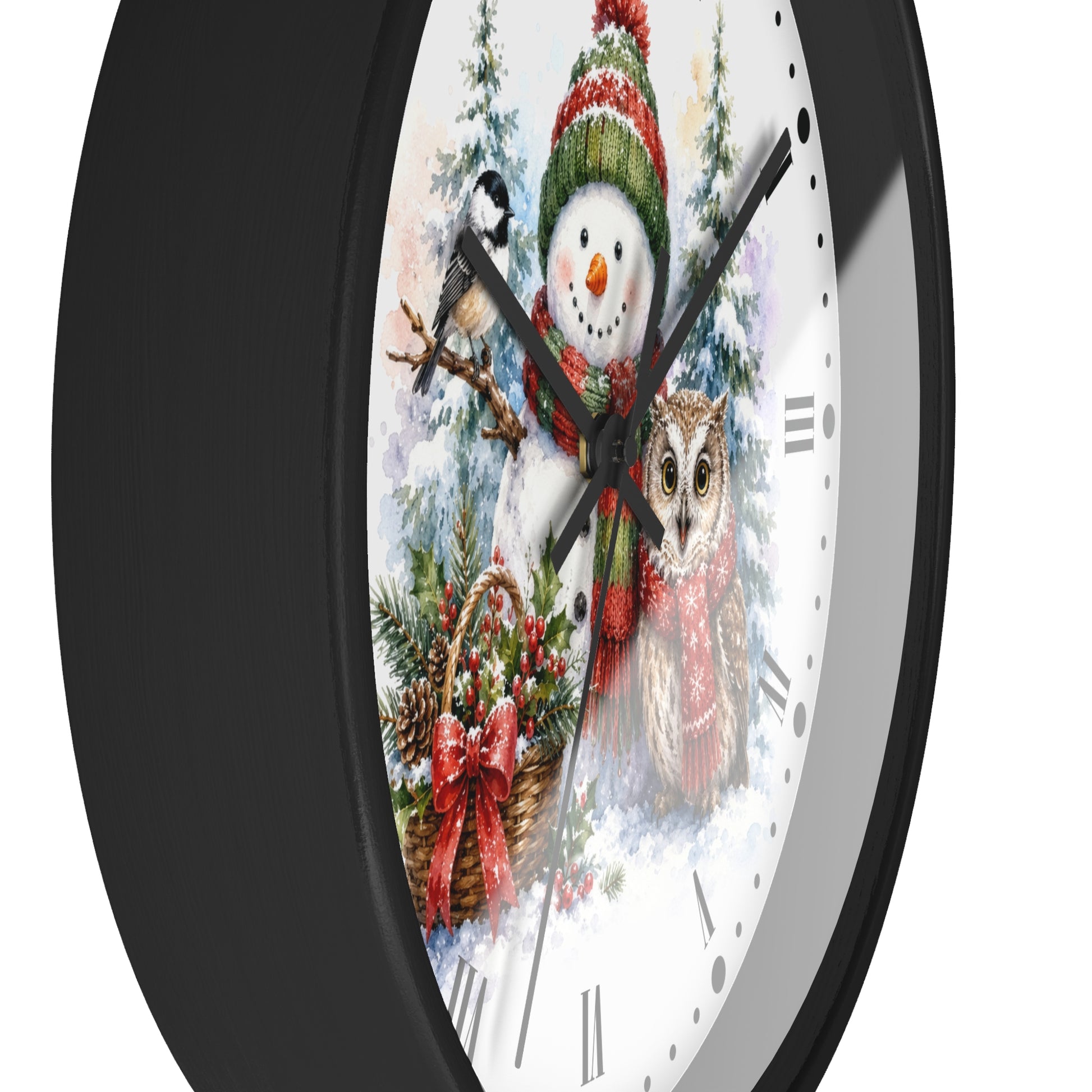 A round wall clock with a black frame and a white face featuring a festive winter illustration of a snowman, owl, bird, and holiday wreath.