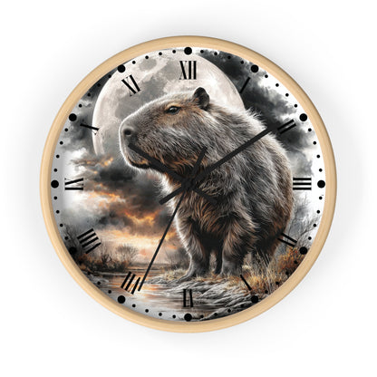 A round wall clock with a light wood frame and a printed scenic dial featuring a capybara standing in front of a large full moon and dramatic clouds. The clock uses Roman numerals for hour markers and has black hands and minute markers.
