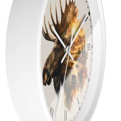 A round white wall clock with a moose head and autumn forest landscape printed on the face, shown against a plain white background.