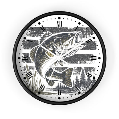 A round wall clock with a black frame and a white face featuring a large black-and-white illustration of a wide mouth bass fish over horizontal stripes, with Roman numerals and black hour markers.