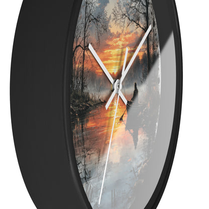 Round wall clock with a black frame and white hands, featuring a scenic print of a winter lake and canoe under an orange sunset sky.