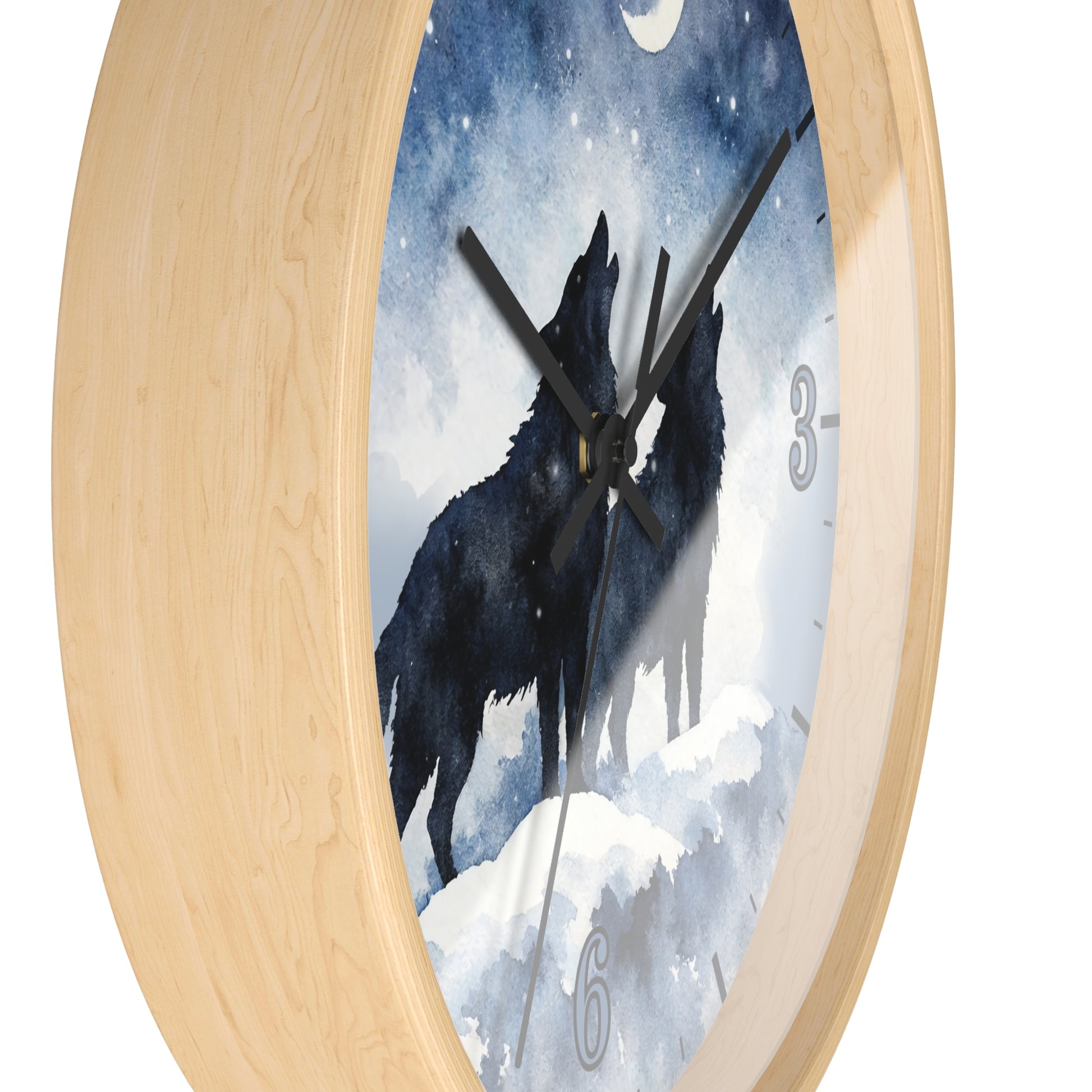 Round wall clock with a light natural wood frame and a printed face showing two black howls in a snowy blue night scene. Partial clock numbers are visible on the right and bottom.