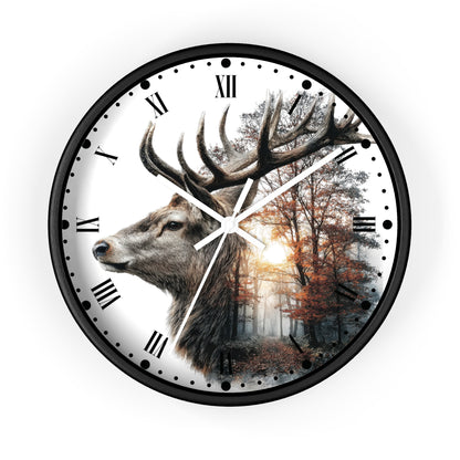 A round wall clock with a black frame and Roman numerals, featuring a printed design of a large deer head over a forest scene with autumn trees and a bright sunburst.