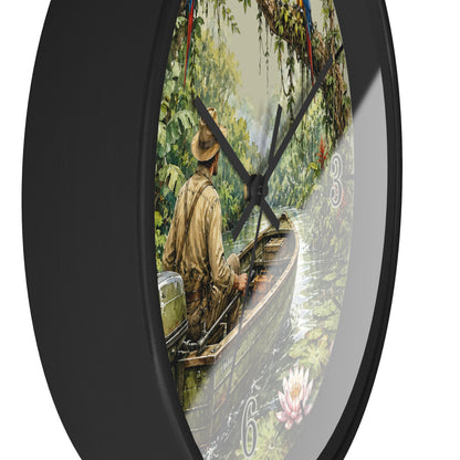 A round wall clock with a black frame and black hands, featuring a scenic illustration of a man in a boat on a river surrounded by lush green trees. The numbers on the clock are stylized as water lilies.