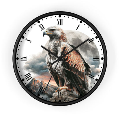 A round wall clock with a black frame and a printed dial featuring a large eagle perched on a rock in front of a cloudy sky and moon, with black Roman numerals and clock hands.