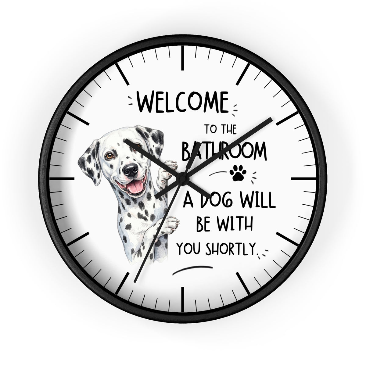 A round wall clock with a black frame and a white face featuring a Dalmatian illustration and the text 'WELCOME TO THE BATHROOM A DOG WILL BE WITH YOU SHORTLY.'.