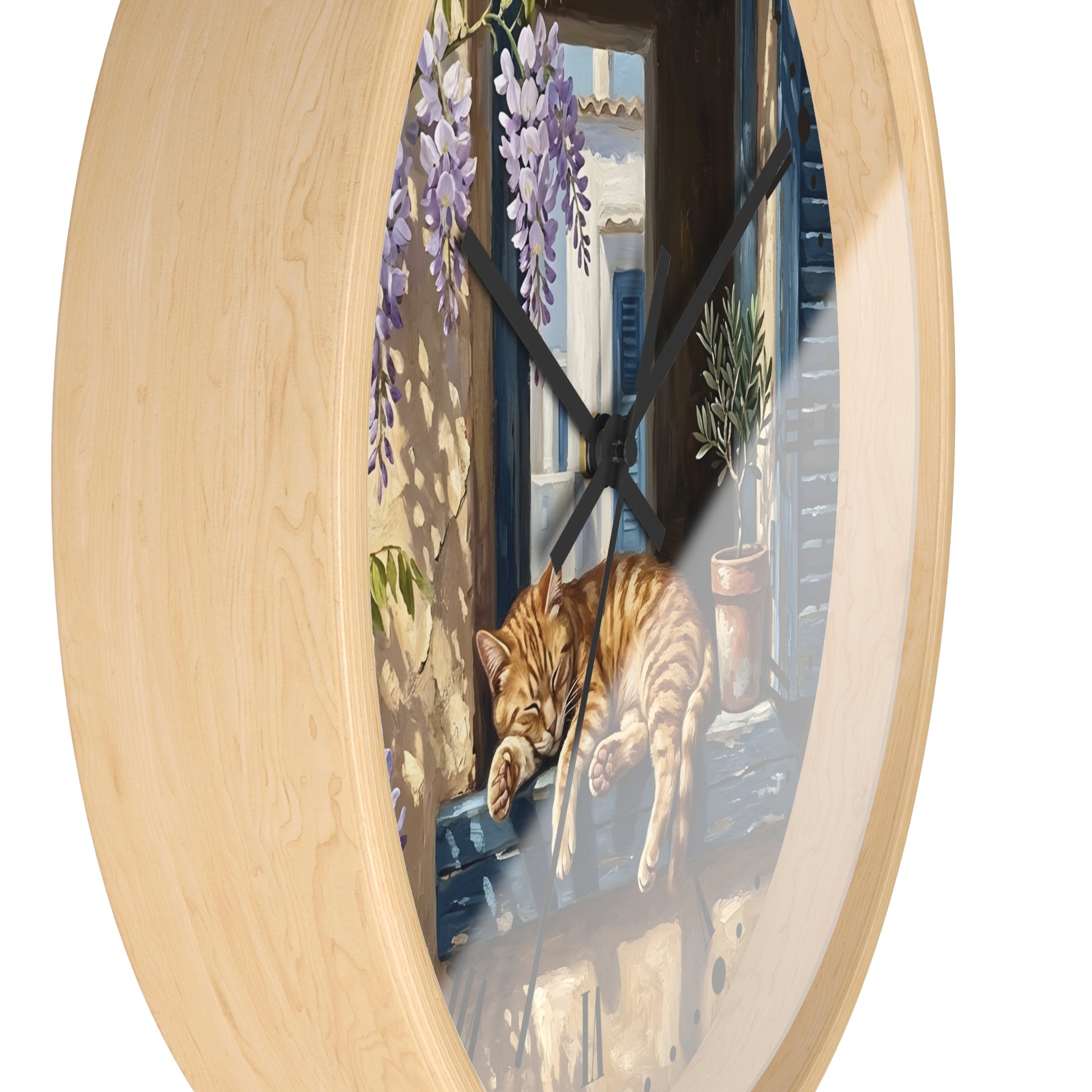 Oval wall clock with a light natural wood frame and a printed illustration of an orange tabby cat sleeping on a windowsill with purple wisteria flowers and a blue-toned window scene.