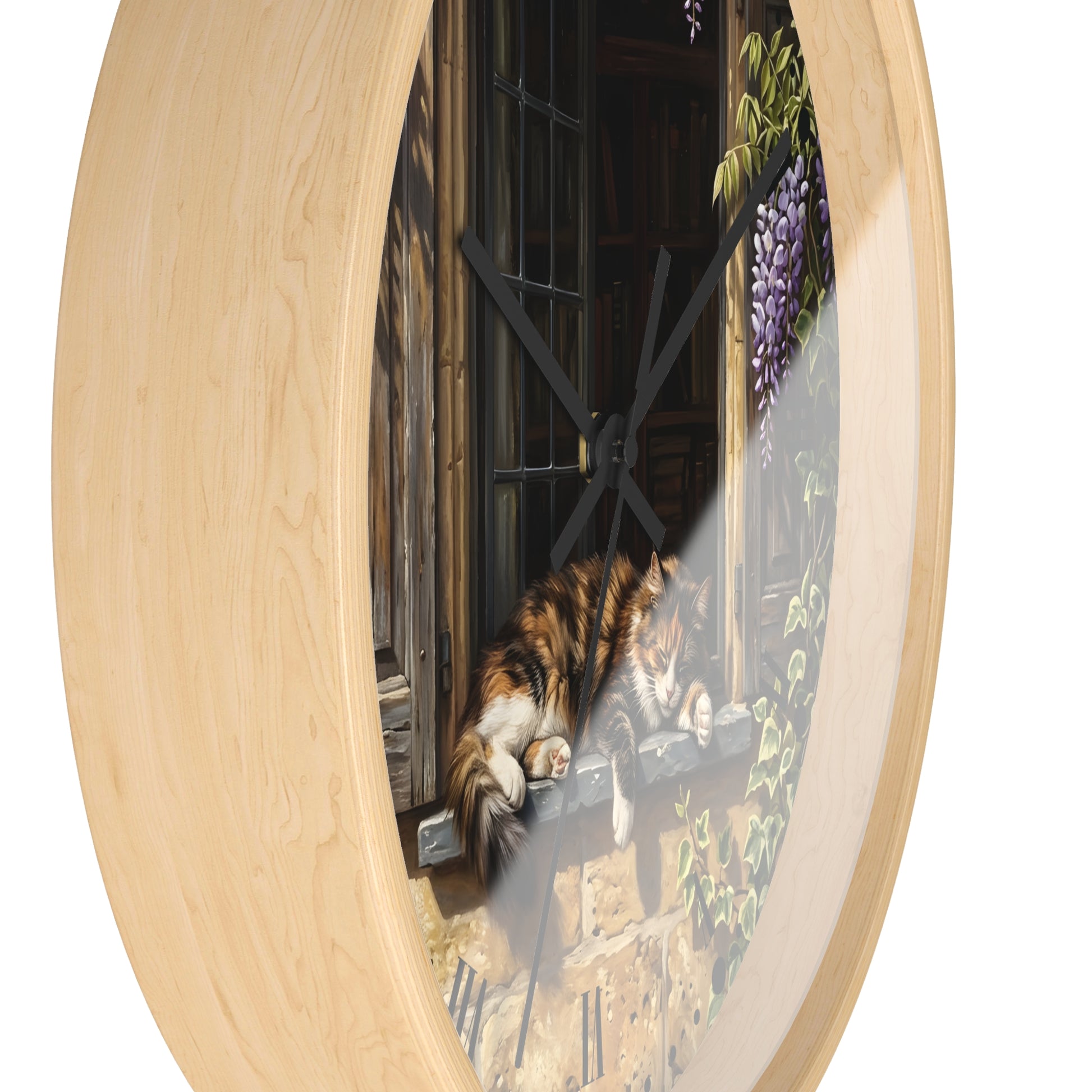 Round wall clock with a light natural wood frame and a printed scenic illustration of a cat resting on a windowsill, shown against a plain white background.