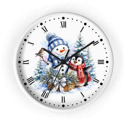 A round white wall clock with black Roman numerals and hands, featuring a festive winter illustration of a snowman in a blue striped hat, a penguin in a red scarf, evergreen trees, and a bird on the clock face.
