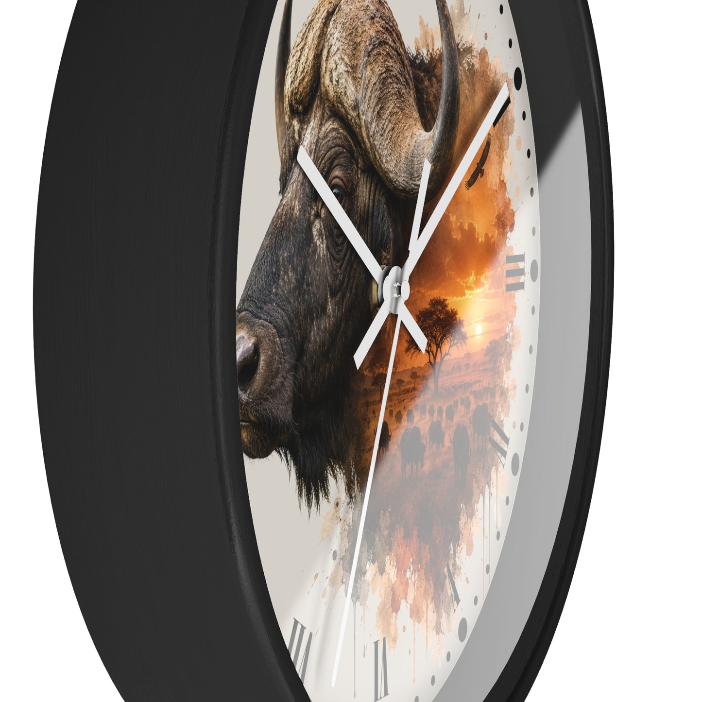A close-up of a round wall clock with a black frame and a printed face showing a bison head over an orange sunset landscape. White clock hands and Roman numerals are visible against a plain white background.