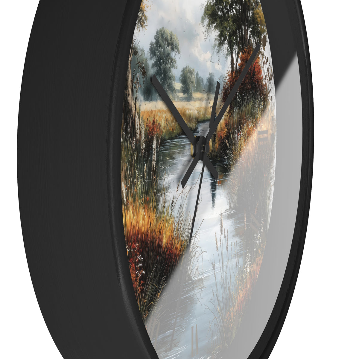 Round wall clock with a black frame and a scenic landscape print of a stream running through a grassy field, shown against a plain white background.