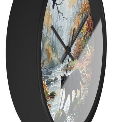 Round wall clock with a black frame and a printed autumn forest face featuring a black cat silhouette, water stream, and colorful foliage.
