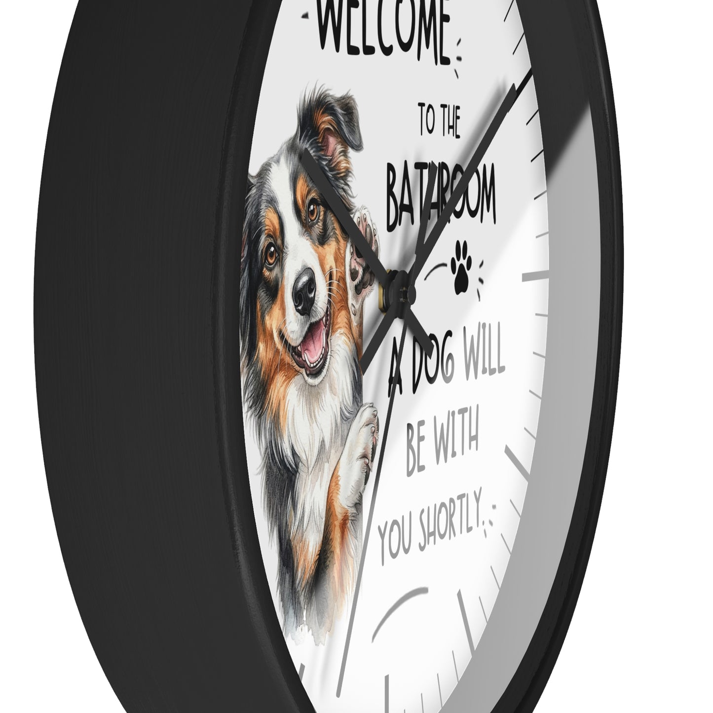 A round wall clock with a black frame and a white face featuring a painted dog portrait and the text 'WELCOME TO THE BATROOM A DOG WILL BE WITH YOU SHORTLY'.