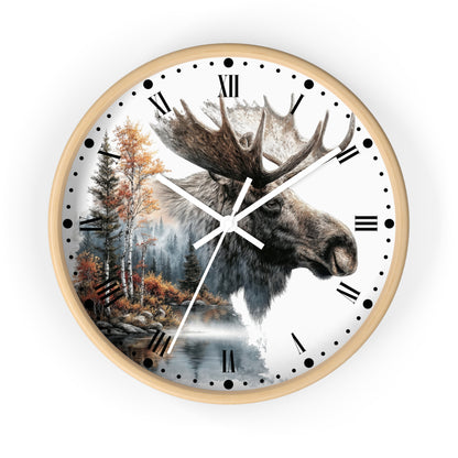 A round wall clock with a light wood frame and a white face featuring a moose head over a forest and lake scene, with black Roman numerals and white hands.