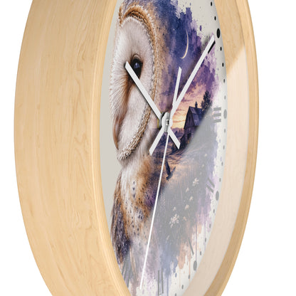 Round wall clock with a light natural wood frame and a printed owl artwork on the face. The design shows a large owl in cream and brown tones beside a purple and blue watercolor landscape with a small house and moon.